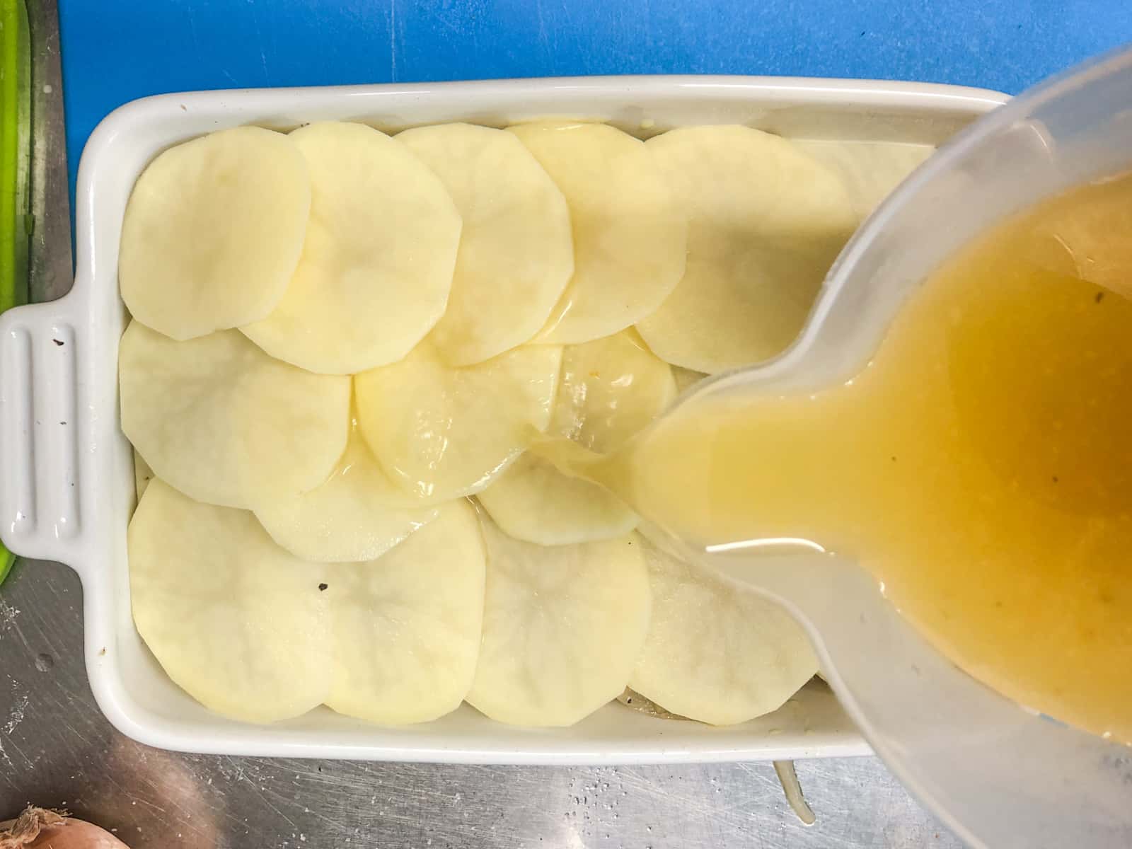 The fianl stages of preparing boulangere potatoes is to add the vegetable stock to just under the potato level.